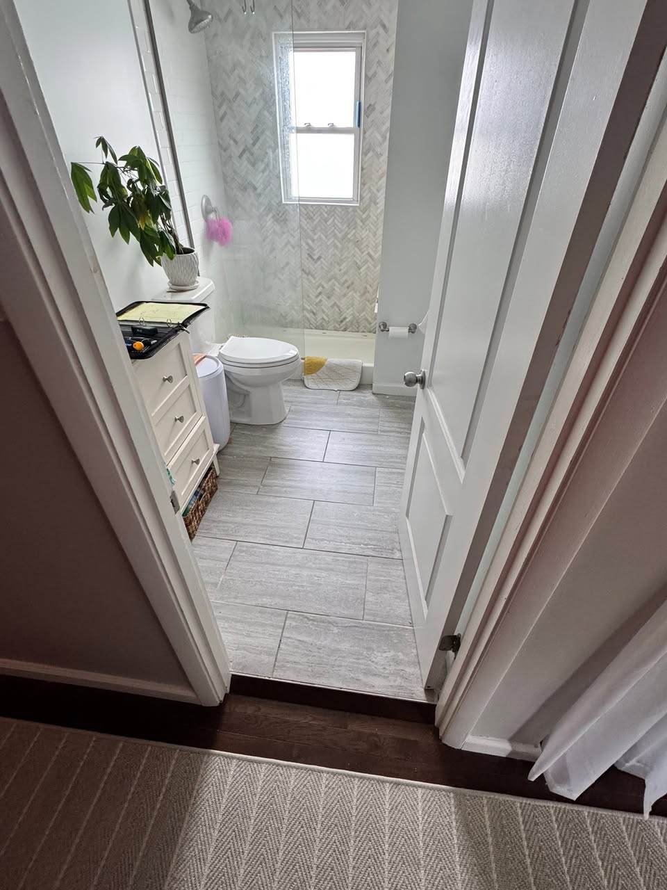 Remodelled bathroom with a dark wood vanity, framed mirror and patterned hexagonal tile floor