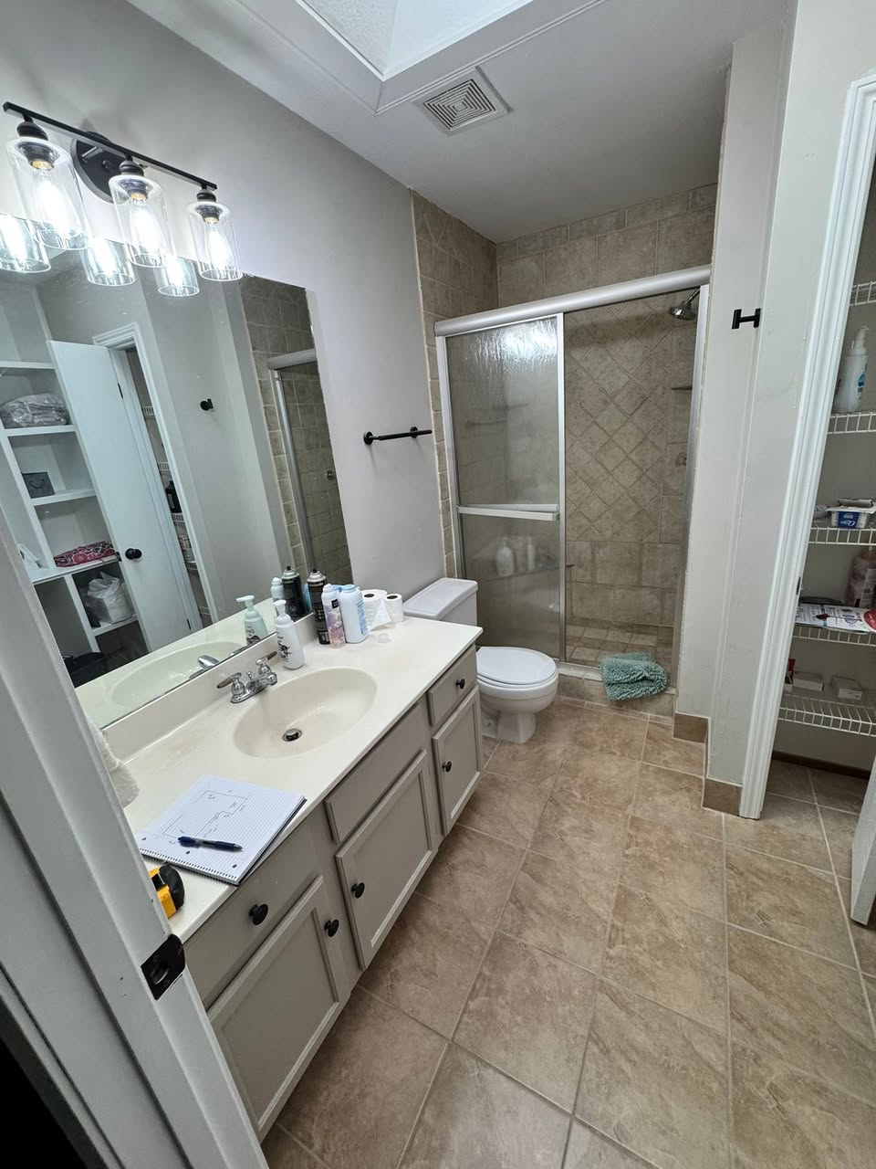 Bright bathroom with a long double vanity, wide mirror and tiled floor