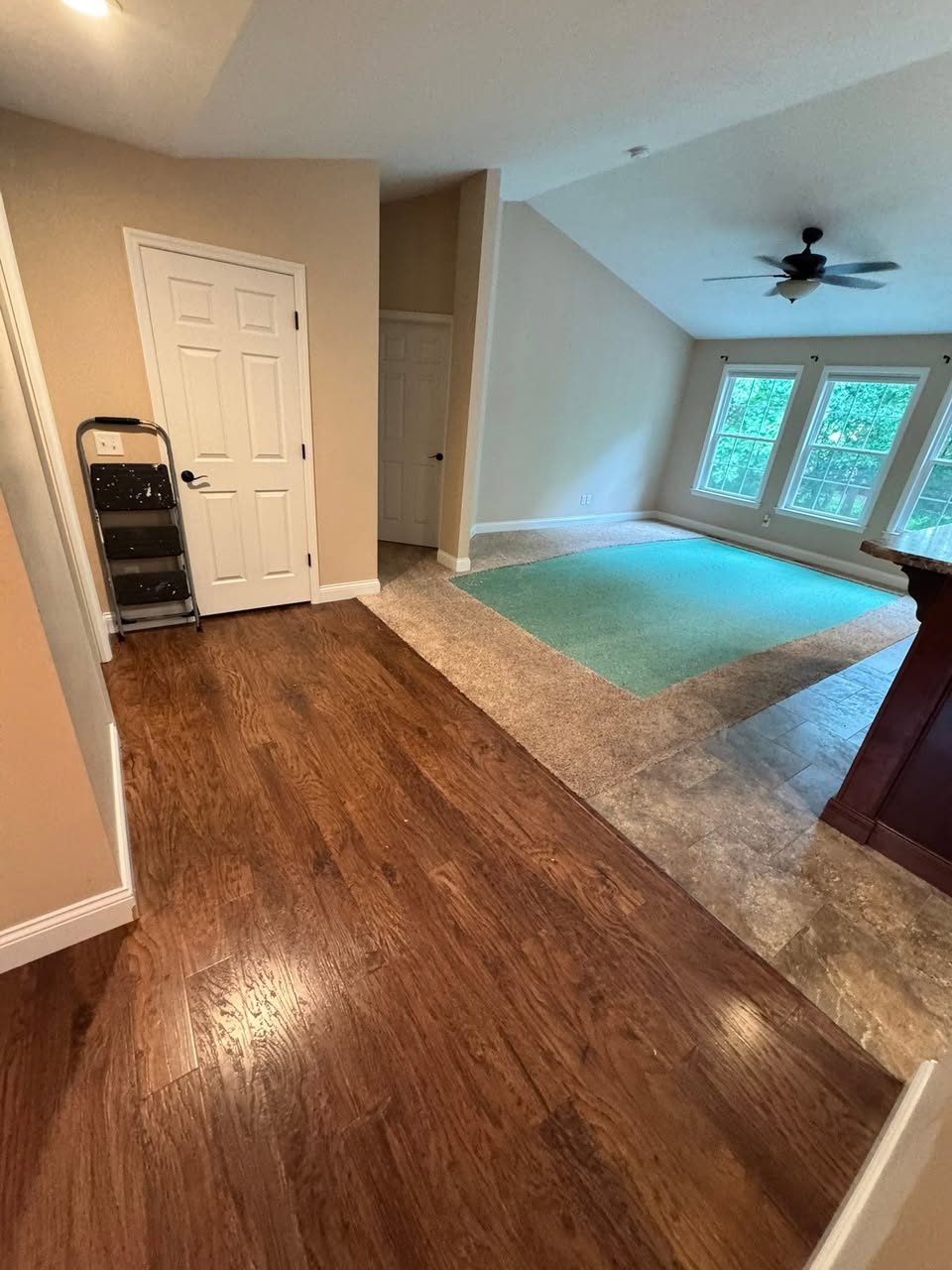 Open room with newly laid hardwood flooring and fresh trim and paint